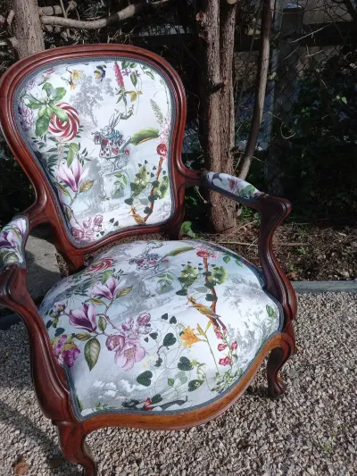 Fauteuil médaillon en bois sculpté, tissu fleuri sur fond blanc